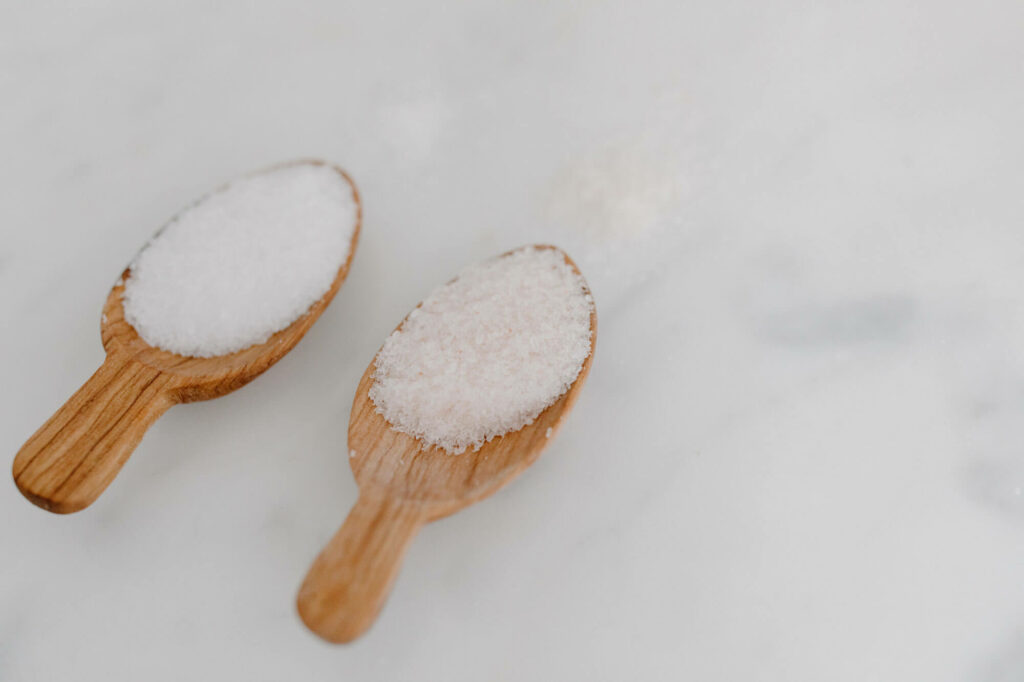 Two small wooden spoons with different types of salts in each, How Much Magnesium Do You Need Daily