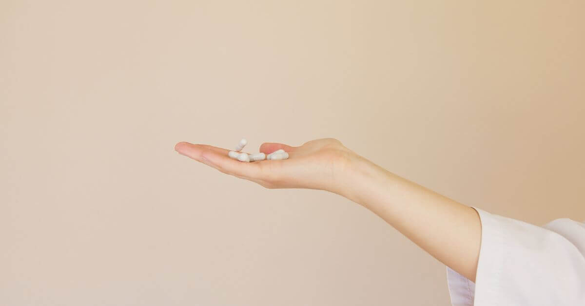 An outstretched hand with about 6 white magnesium pill capsules in it, When’s the Best Time To Take Magnesium