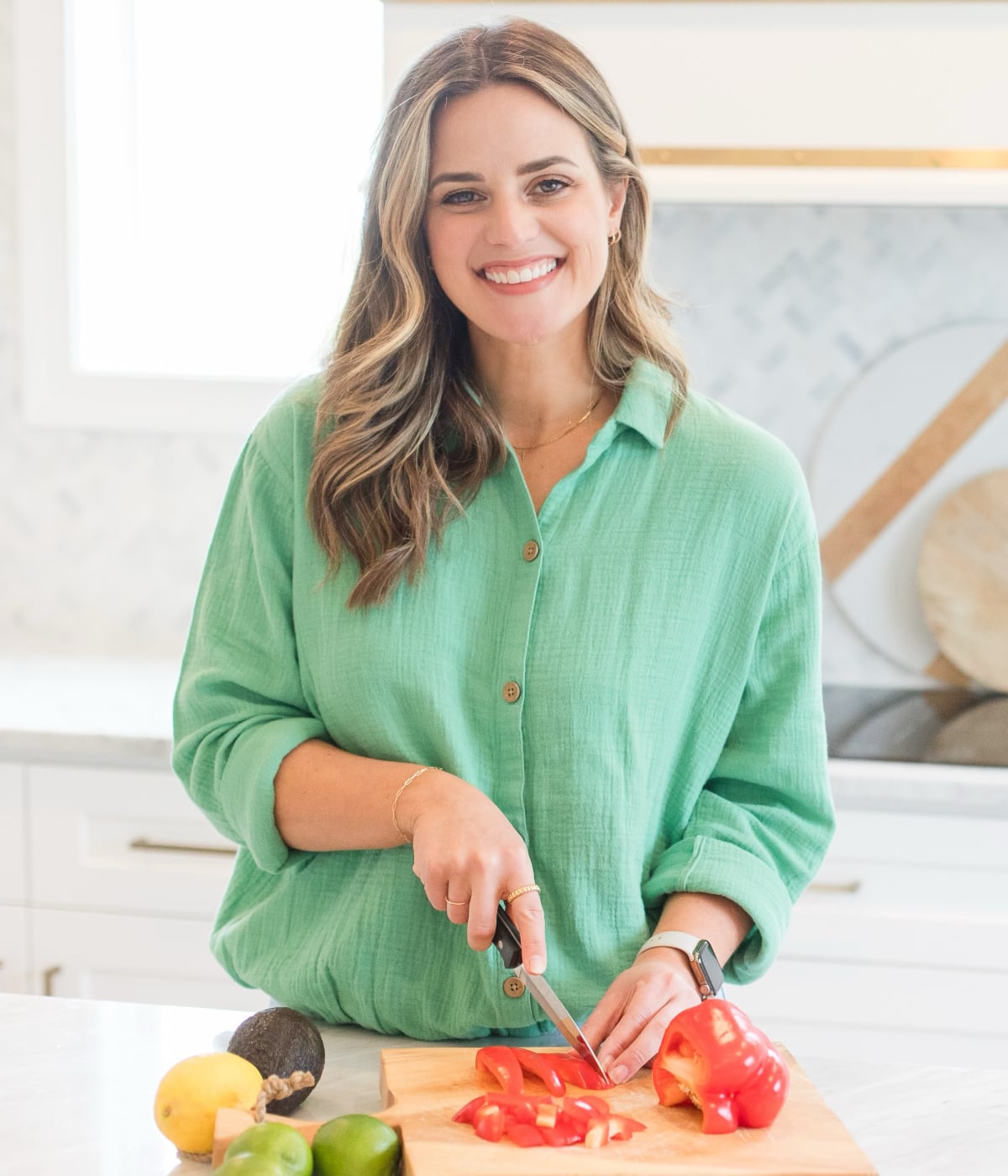 Noelle Tarr, founder of Well Minerals natural vitamins and supplements, tops a key lime pie with whipped cream in a modern kitchen